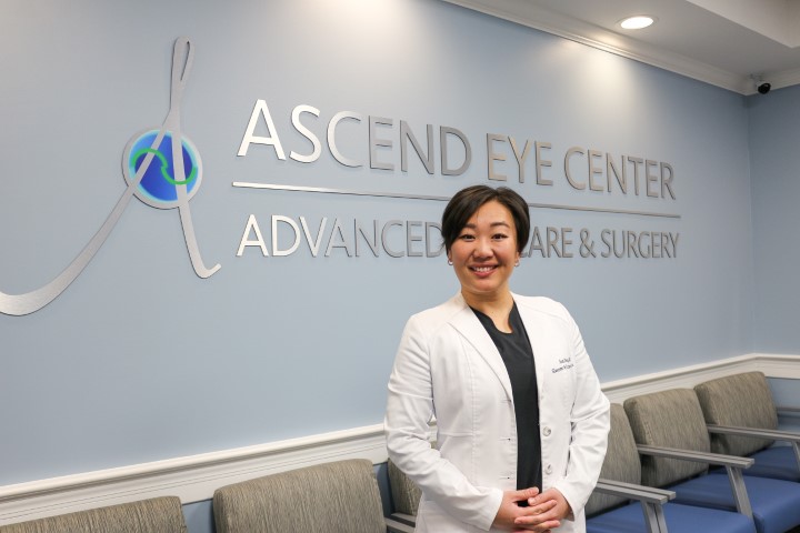 Dr. Ding standing by her office sign